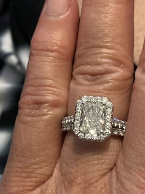 Lab grown radiant center stone in natural diamond halo setting in white gold.